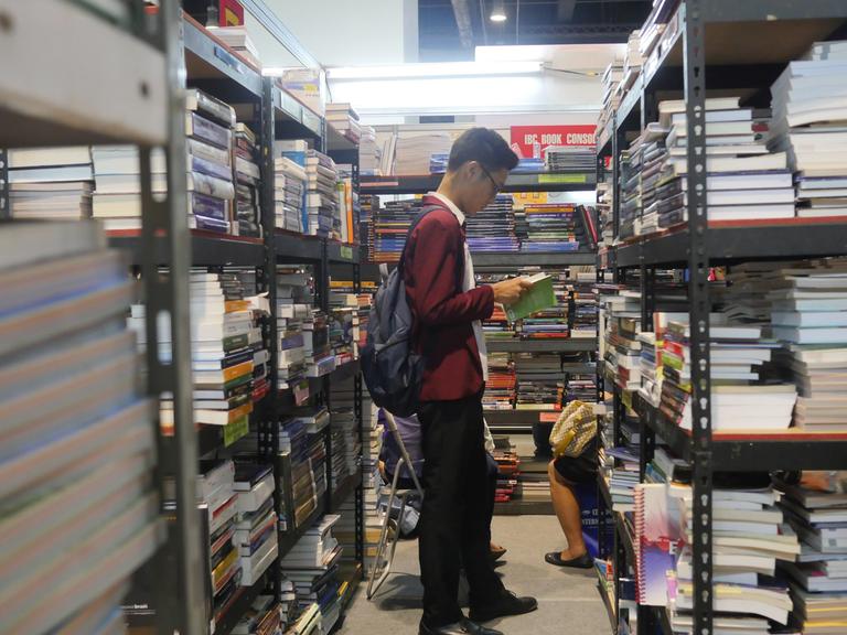 Ein Mann liest in einer Buchhandlung ein Buch - auf der 37. Internationalen Buchmesse in Manila
