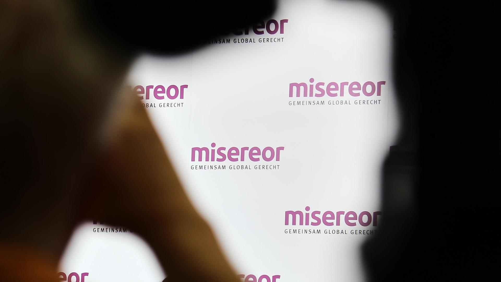 Der Schriftzug von Misereor mehrals an einer Wand, davor Schatten