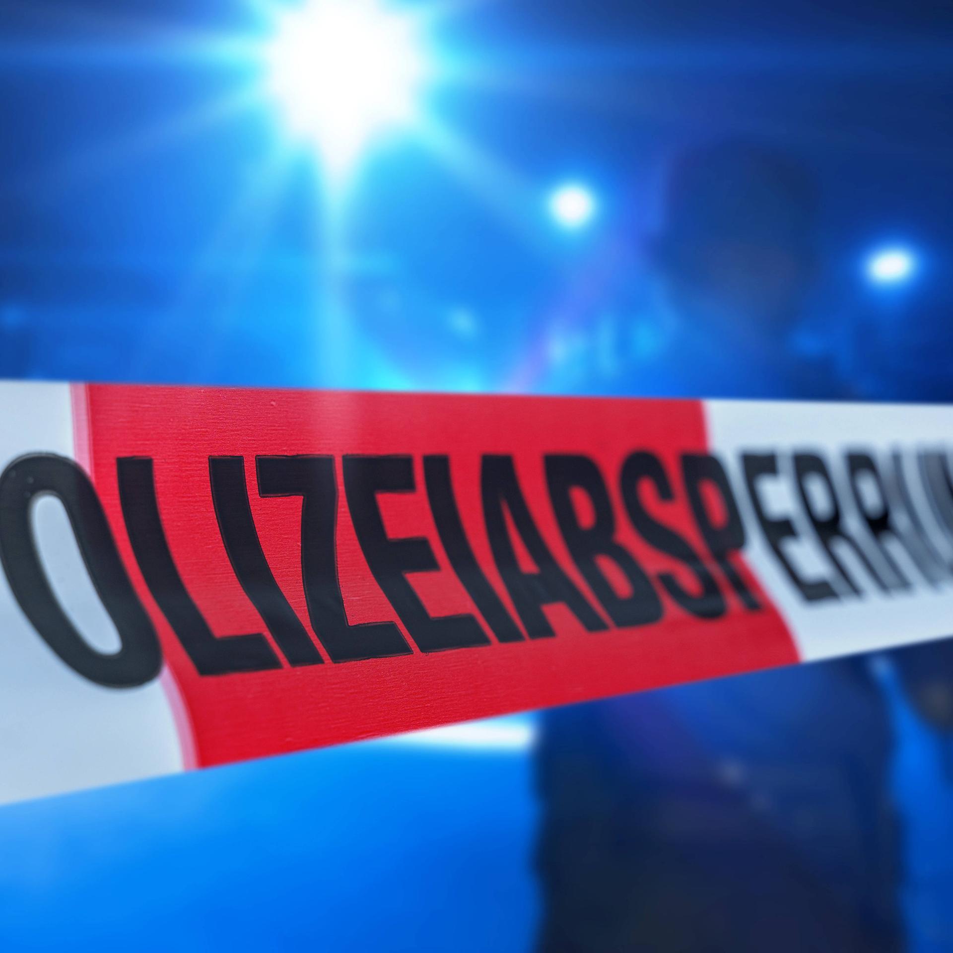 Augsburg, Bavaria, Germany - July 6, 2023: Police cordon, cordon tape before a police operation with blue lights. Symbol image crime and crime scene PHOTOMONTAGE *** Polizeiabsperrung, Absperrband vor einem Polizeieinsatz mit Blaulicht. Symbolbild Verbrechen und Tatort FOTOMONTAGE