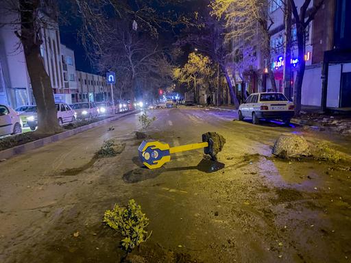 Steine, Äste und eine umgestürzte Spendenbox liegen während Unruhen im iranischen Hamedan auf einer Straße. Es handelt derzeit um die größten Proteste in der Islamischen Republik seit drei Jahren.