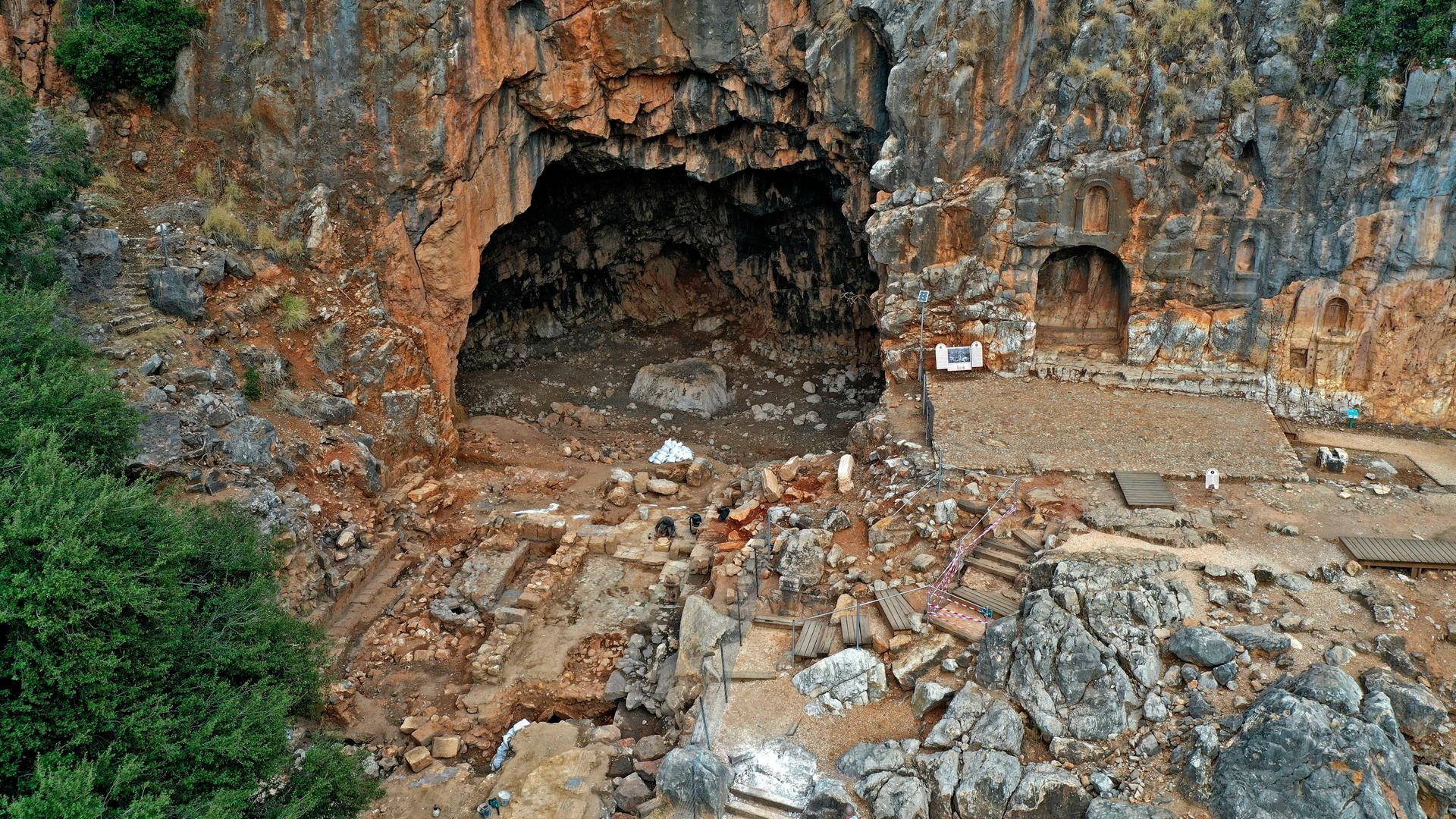 Eine Felsenwand mit Höhle und etliche antike Gebäudereste Eine Felsenwand mit Höhle und etliche antike Gebäudereste