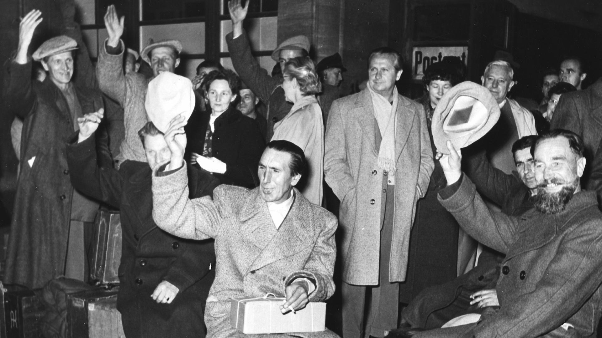 Schwarz-Weiß-Aufnahme einer Gruppe von Heimkehrern vor dem Bahnhof Zoo in Berlin Schwarz-Weiß-Aufnahme einer Gruppe von Heimkehrern vor dem Bahnhof Zoo in Berlin