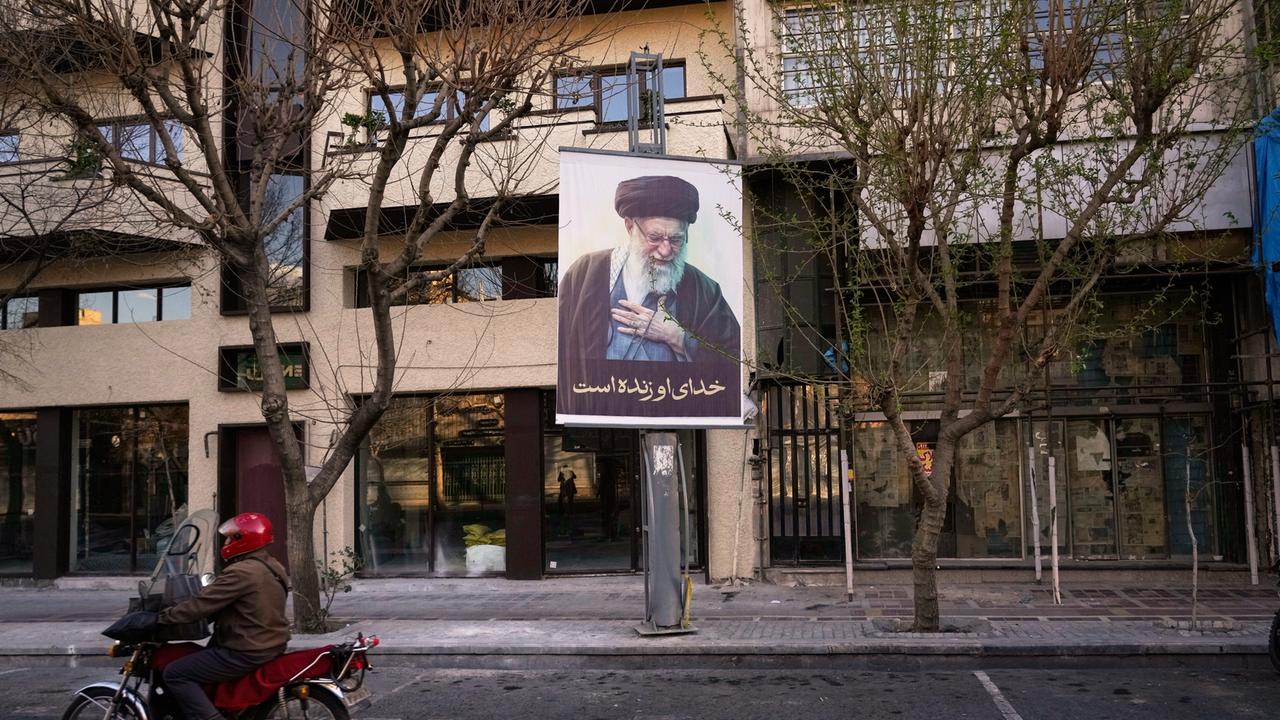 Ein Motorrad fährt in Teheran an einem Plakat mit dem Bild des iranischen Obersten Führers Ali Chamenei vorbei, nachdem dessen Tod durch einen Luftangriff bestätigt wurde.