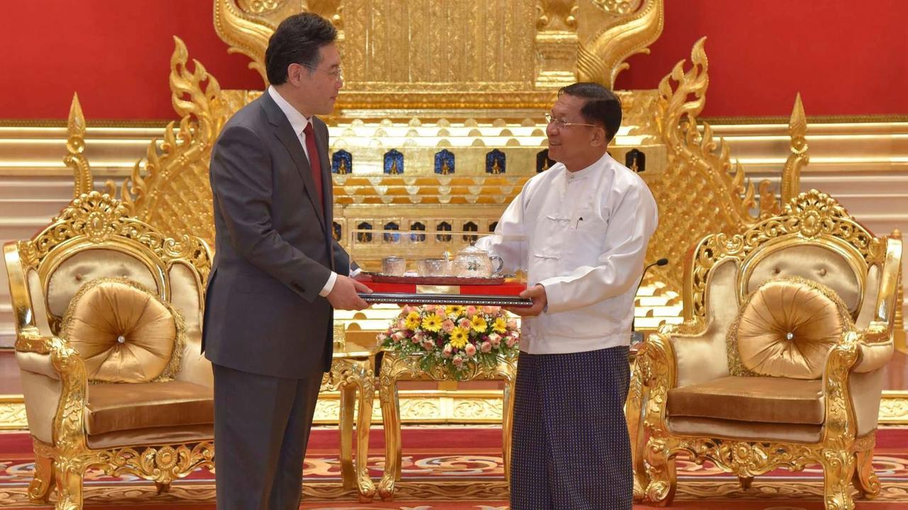 Chinas Außenminister Qin übergibt dem Mitglied der Militärführung in Myanmar, Senior General Min Aung Hlaing ein Gastgeschenk.