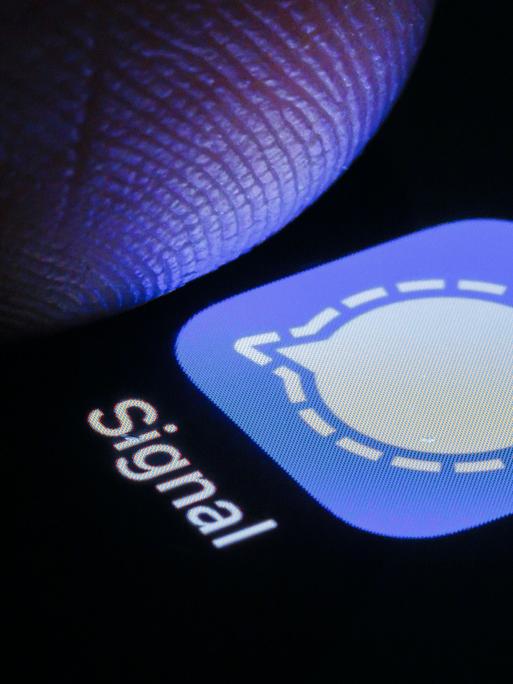 Nahaufnahme eines Fingers, der auf einem Smartphonescreen auf die Signal-App tippt.