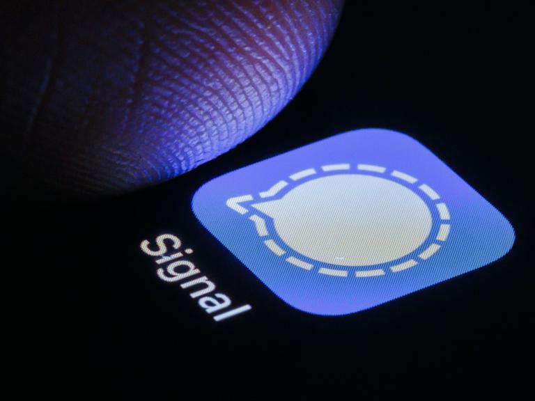 Nahaufnahme eines Fingers, der auf einem Smartphonescreen auf die Signal-App tippt.