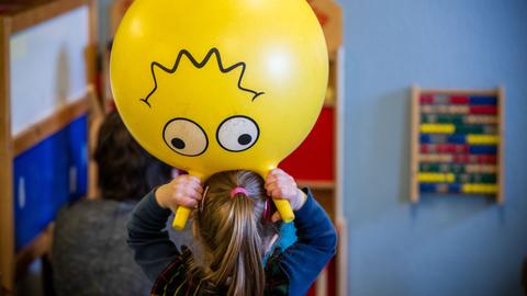 Kleinkinder toben in einem Spielzimmer.