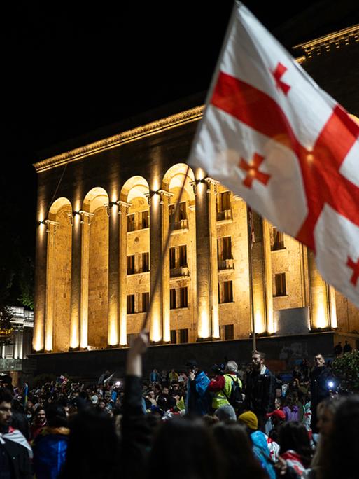 Demonstranten vor dem Parlament in Georgien schwenken georgische Flaggen