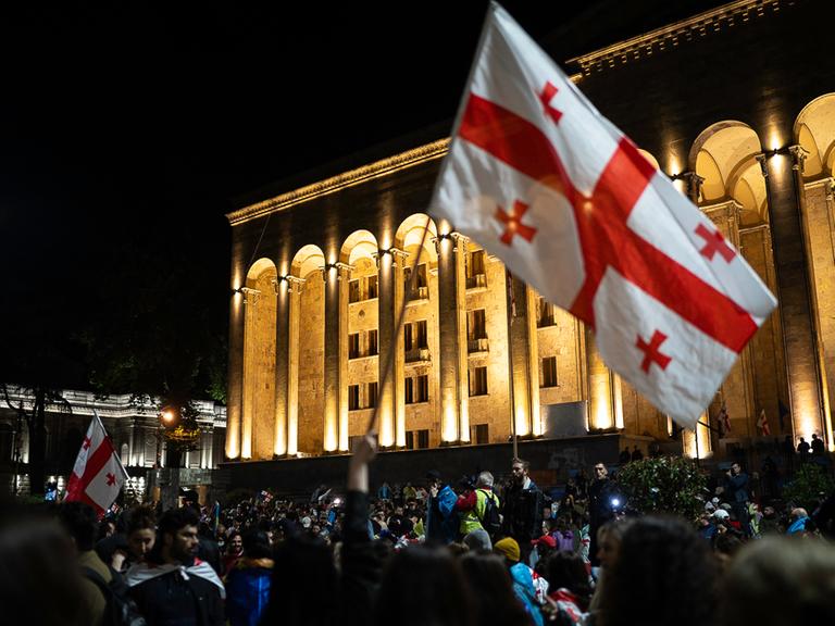 Demonstranten vor dem Parlament in Georgien schwenken georgische Flaggen
