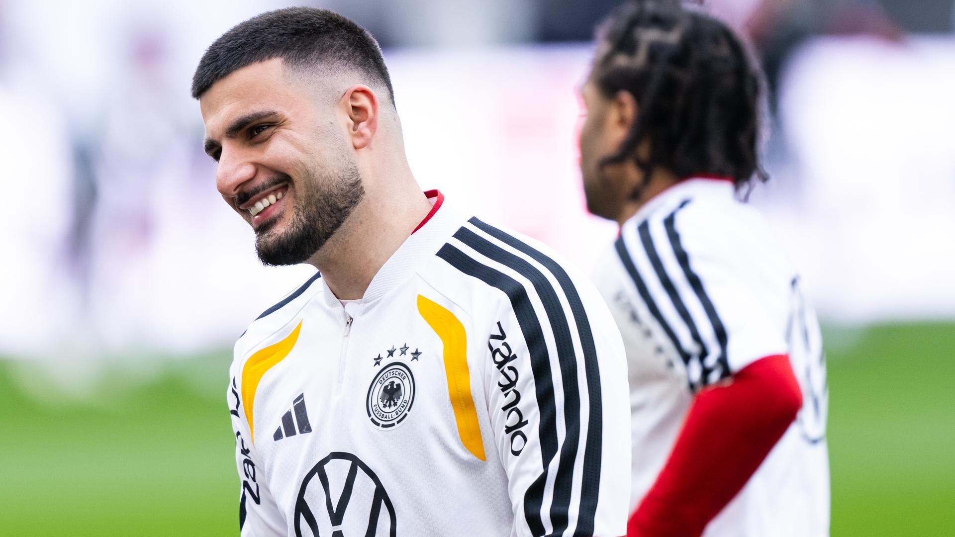 Stürmer Deniz Undav lacht auf dem Fußballplatz.