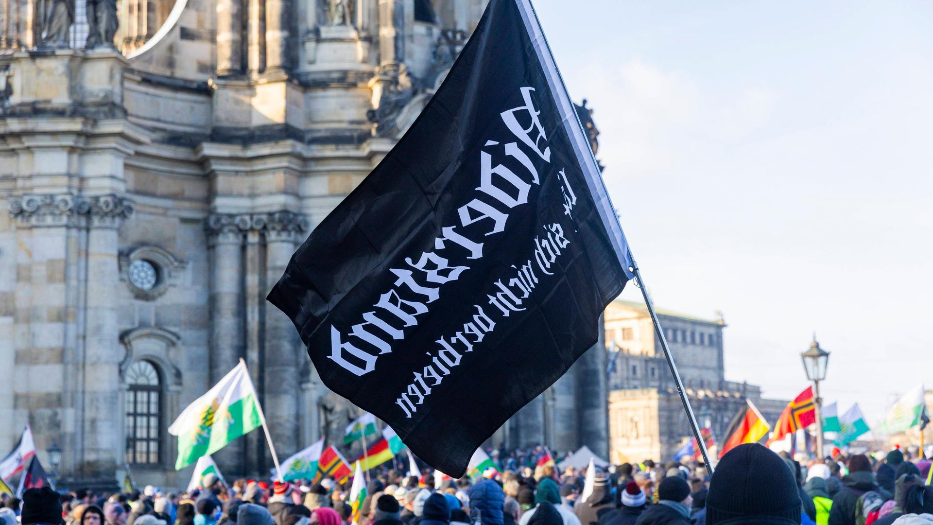 Demonstration in Dresden: Tausende Menschen demonstrieren auf dem Schlossplatz in Dresden und ziehen dann durch die Innenstadt. Dabei sind Fahnen des einstigen Königreiches Sachsen, die häufig von Anhängern der rechtsextremen Kleinstpartei Freie Sachsen mitgeführt werden, zu sehen. 