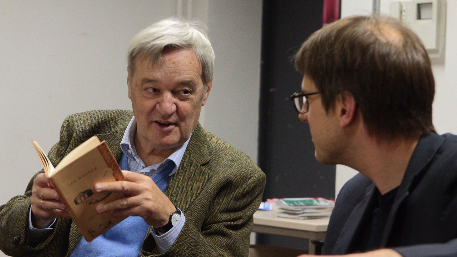 Harald Hartung hält ein Buch in der hand, rechts neben ihm sitzt der Schriftsteller Jan Wagner. Harald Hartung hält ein Buch in der hand, rechts neben ihm sitzt der Schriftsteller Jan Wagner.