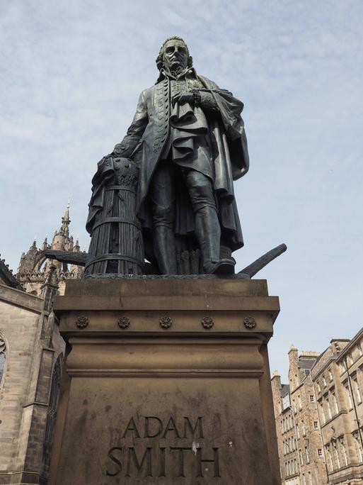 Eine Statue von Adam Smith steht auf einem Sockel, der mit seinem Namen beschriftet ist.