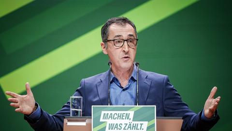 Özdemir steht hinter einem Rednerpult und gestikuliert mit beiden Armen
