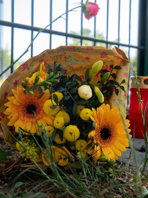 Blumen und eine Kerze erinnern an einem Zaun in Lichtenberg an einen 15-Jährigen aus Berlin, der nach einer Schlägerei bei einem Turnier in Frankfurt/Main verstarb.
