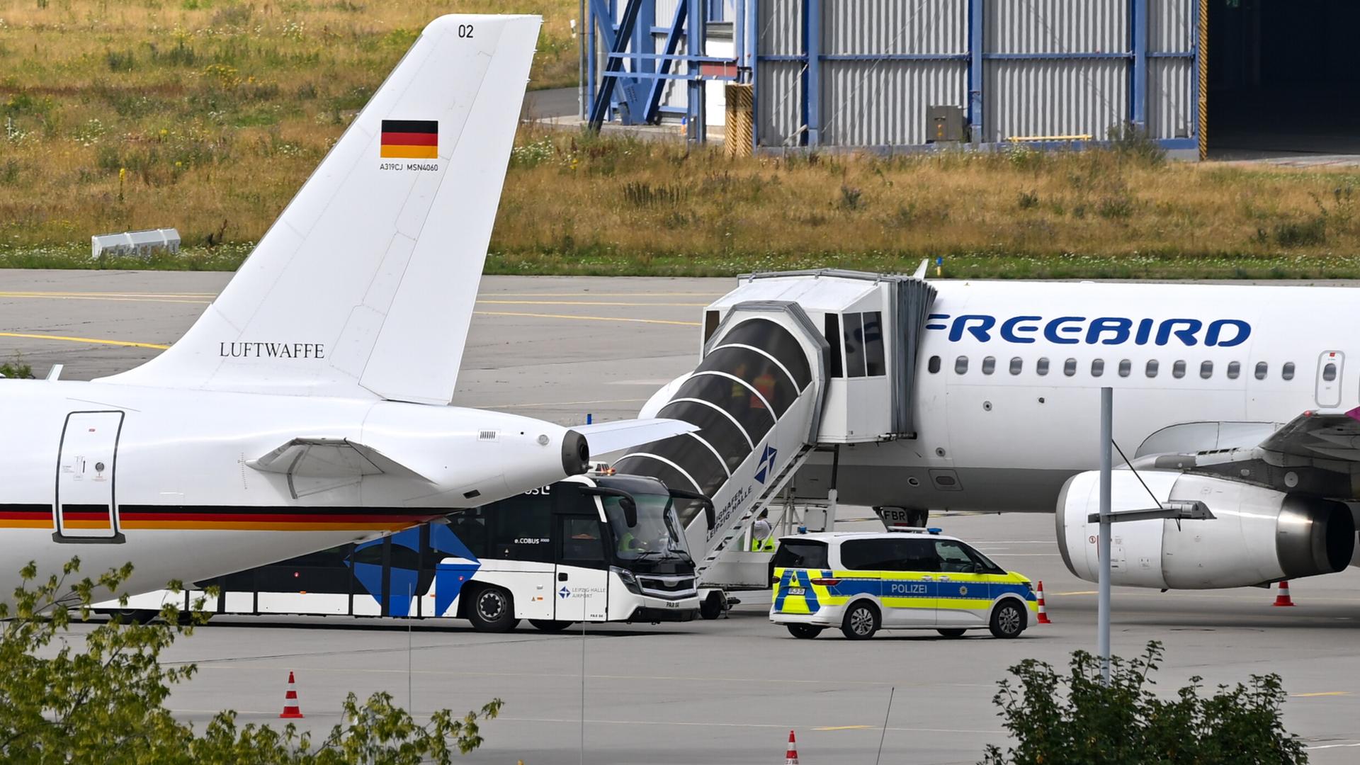 Auf dem Gelände des Leipziger Flughafen stehen zwei Flugzeuge und ein Polizeiauto