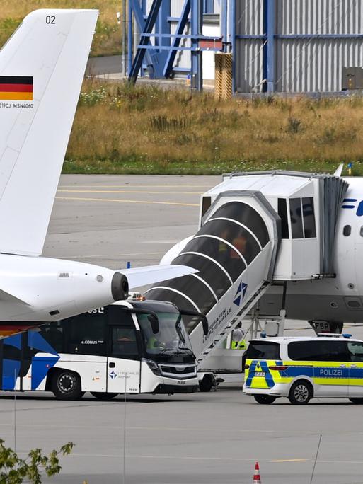 Auf dem Gelände des Leipziger Flughafen stehen zwei Flugzeuge und ein Polizeiauto