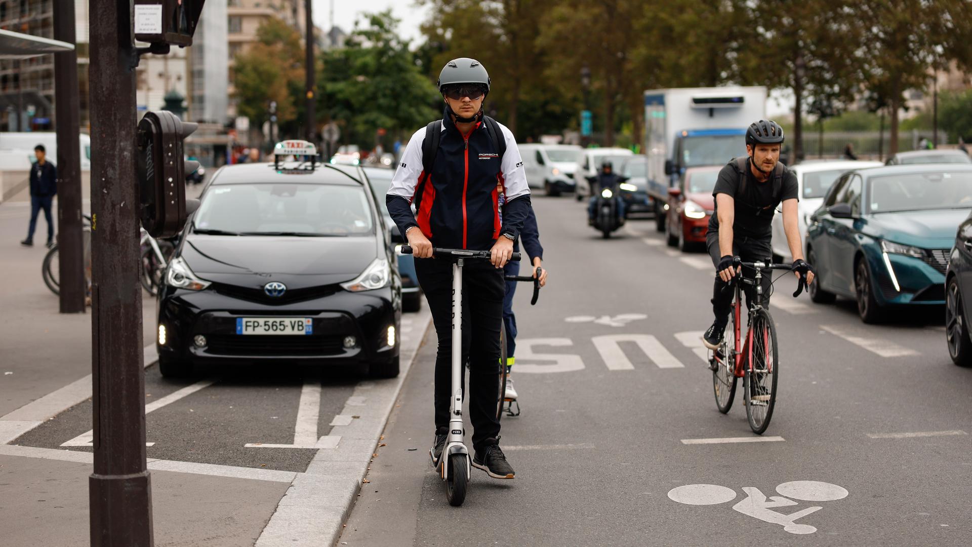 Ein E-Scooter-Fahrer mit Helm in Paris Ein E-Scooter-Fahrer mit Helm in Paris