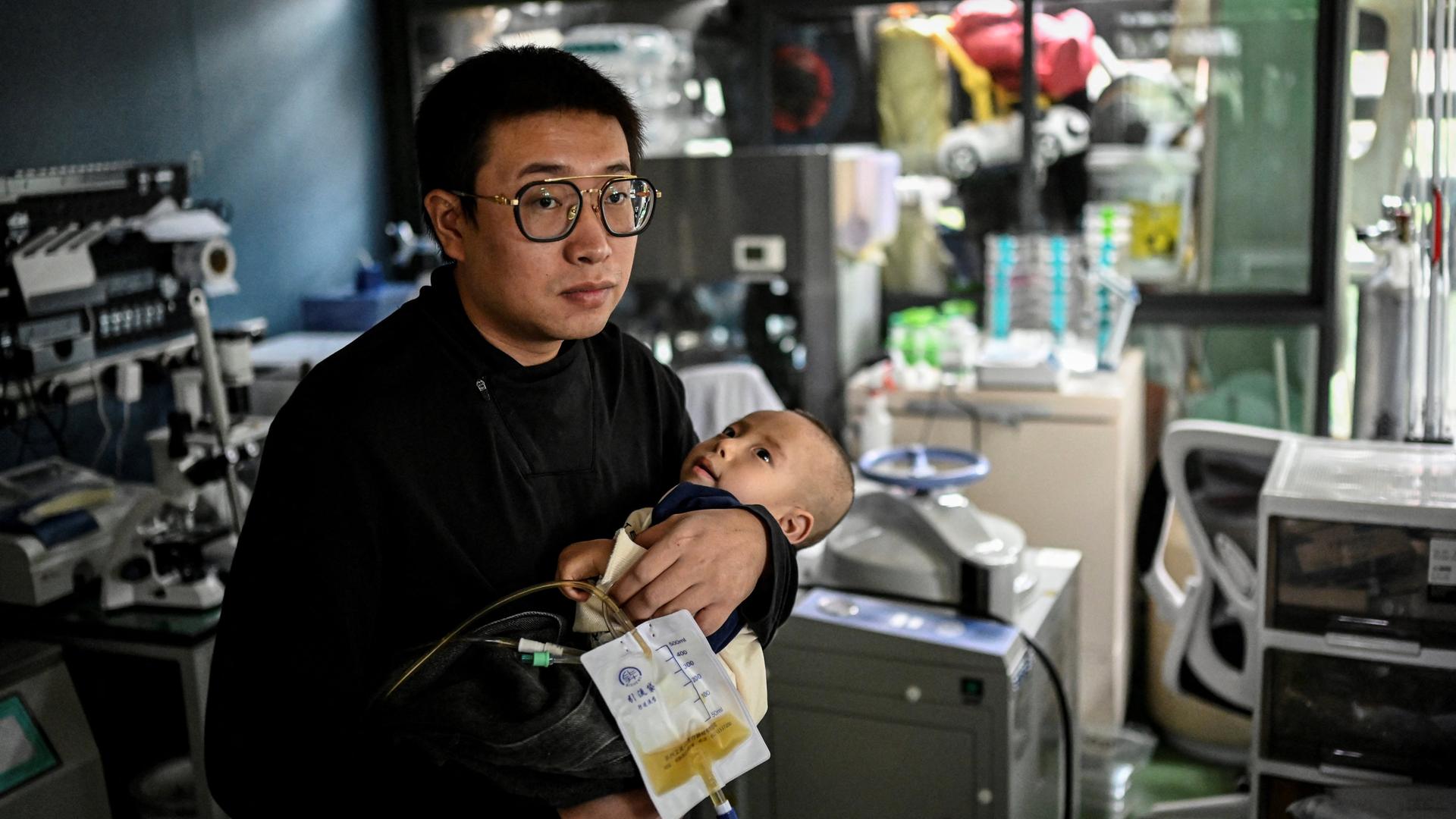 Das am 20. Oktober 2021 aufgenommene Foto zeigt Xu Wei (links), wie er seinen Sohn Xu Haoyang, bei dem das Menkes-Syndrom diagnostiziert wurde, in seinem Heimlabor in Kunming in der südwestchinesischen Provinz Yunnan im Arm hält. Das am 20. Oktober 2021 aufgenommene Foto zeigt Xu Wei (links), wie er seinen Sohn Xu Haoyang, bei dem das Menkes-Syndrom diagnostiziert wurde, in seinem Heimlabor in Kunming in der südwestchinesischen Provinz Yunnan im Arm hält.