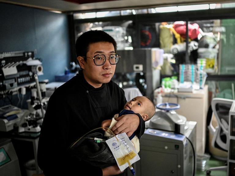 Das am 20. Oktober 2021 aufgenommene Foto zeigt Xu Wei (links), wie er seinen Sohn Xu Haoyang, bei dem das Menkes-Syndrom diagnostiziert wurde, in seinem Heimlabor in Kunming in der südwestchinesischen Provinz Yunnan im Arm hält. Das am 20. Oktober 2021 aufgenommene Foto zeigt Xu Wei (links), wie er seinen Sohn Xu Haoyang, bei dem das Menkes-Syndrom diagnostiziert wurde, in seinem Heimlabor in Kunming in der südwestchinesischen Provinz Yunnan im Arm hält.