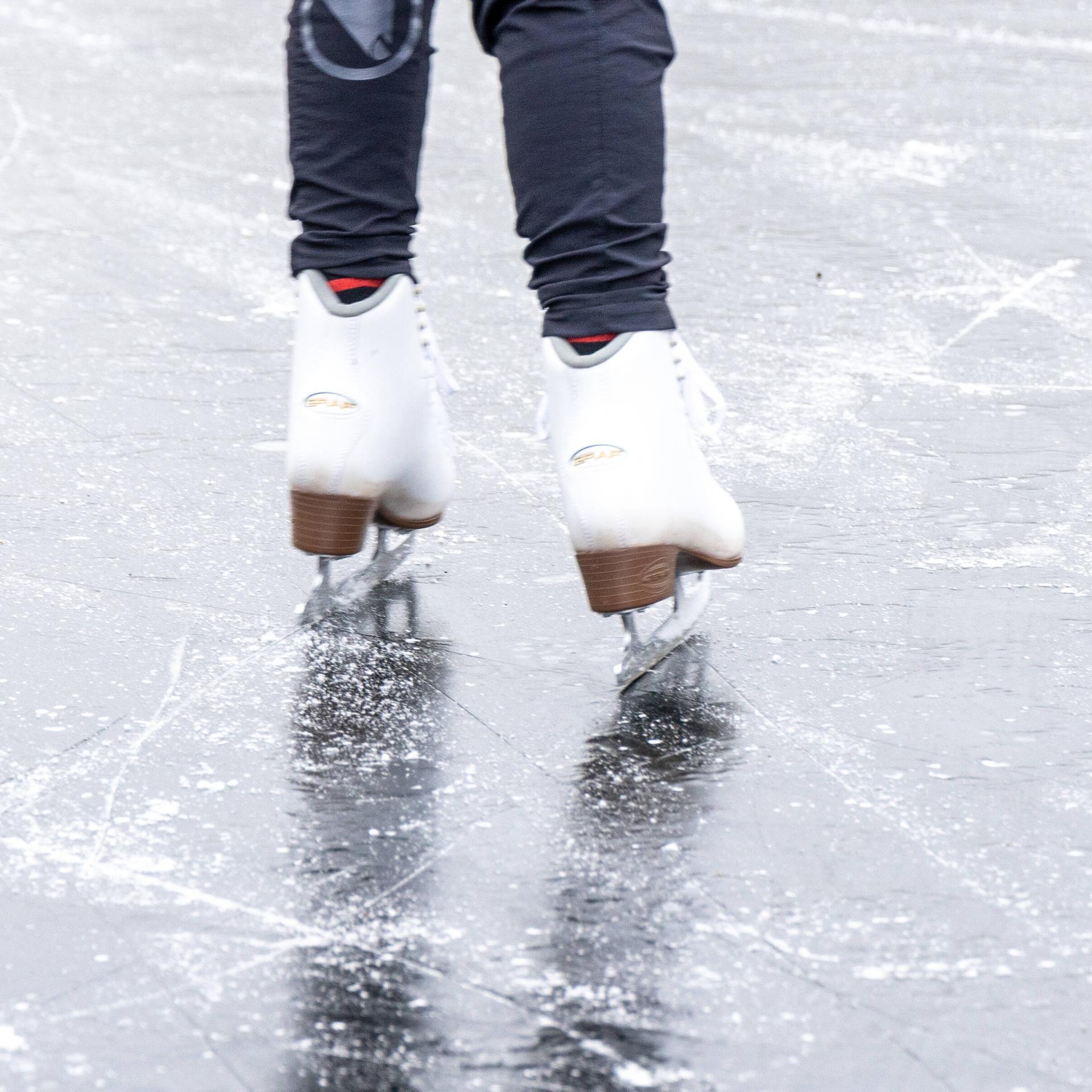 Menschen fahren an einem Sonntag Schlittschuh, spielen Eishockey oder rutschen auf der seit gestern zugefrorenen Krummen Lanke See im Bezirk Zehlendorf bei Temperaturen von minus fünf Grad Celsius.