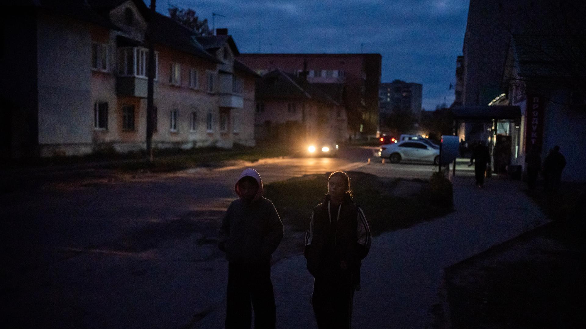 Schostka: Kinder gehen während eines Stromausfalls durch eine dunkle Wohnstraße. Schostka: Kinder gehen während eines Stromausfalls durch eine dunkle Wohnstraße.