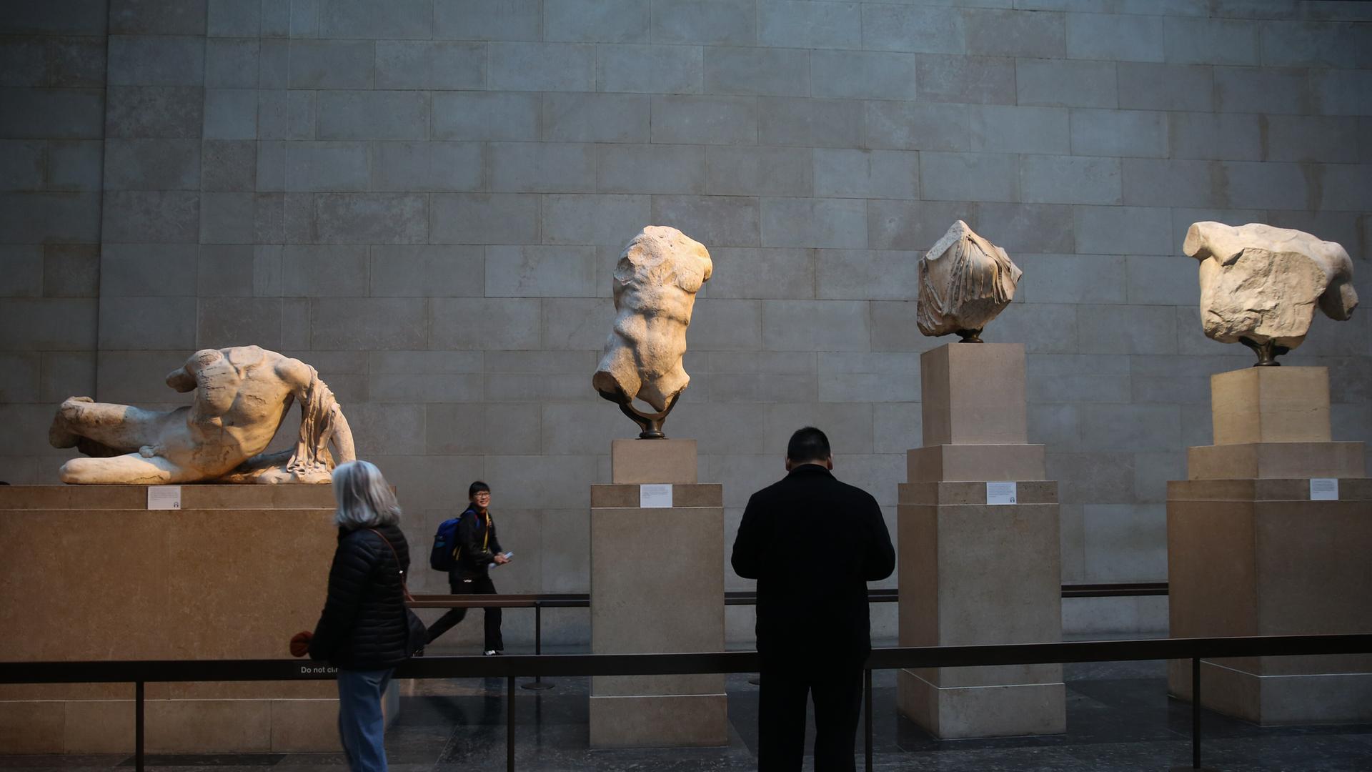 Besucher betrachten die Elgin-Skulpturen, auch bekannt als die Parthenon-Skulpturen, im British Museum in London Besucher betrachten die Elgin-Skulpturen, auch bekannt als die Parthenon-Skulpturen, im British Museum in London