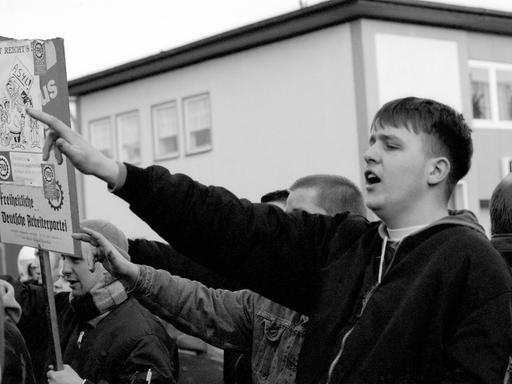 Ein junger Rechtsextremer hebt den Arm in einer Geste die dem Hitlergruß ähnelt.