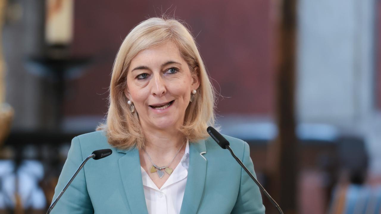 Nina Warken steht an einem Rdepult und spricht vor einem Auditorium in Mikrofone.