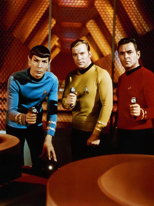 Mr. Spock, Captain James T. Kirk und Scotty (Leonard Nimoy, William Shatner, James Doohan) tragen ihre Raumschiffanzüge aus der Fernsehserie "Star Trek" und halten Waffen in den Händen. Mr. Spock, Captain James T. Kirk und Scotty (Leonard Nimoy, William Shatner, James Doohan) tragen ihre Raumschiffanzüge aus der Fernsehserie "Star Trek" und halten Waffen in den Händen.