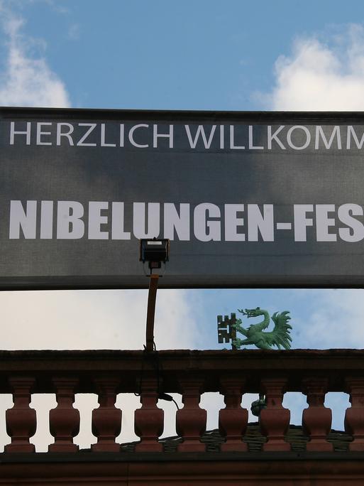 Auf einem Banner über einem Dach steht "Willkommen zu den Niebelungen-Festspielen"