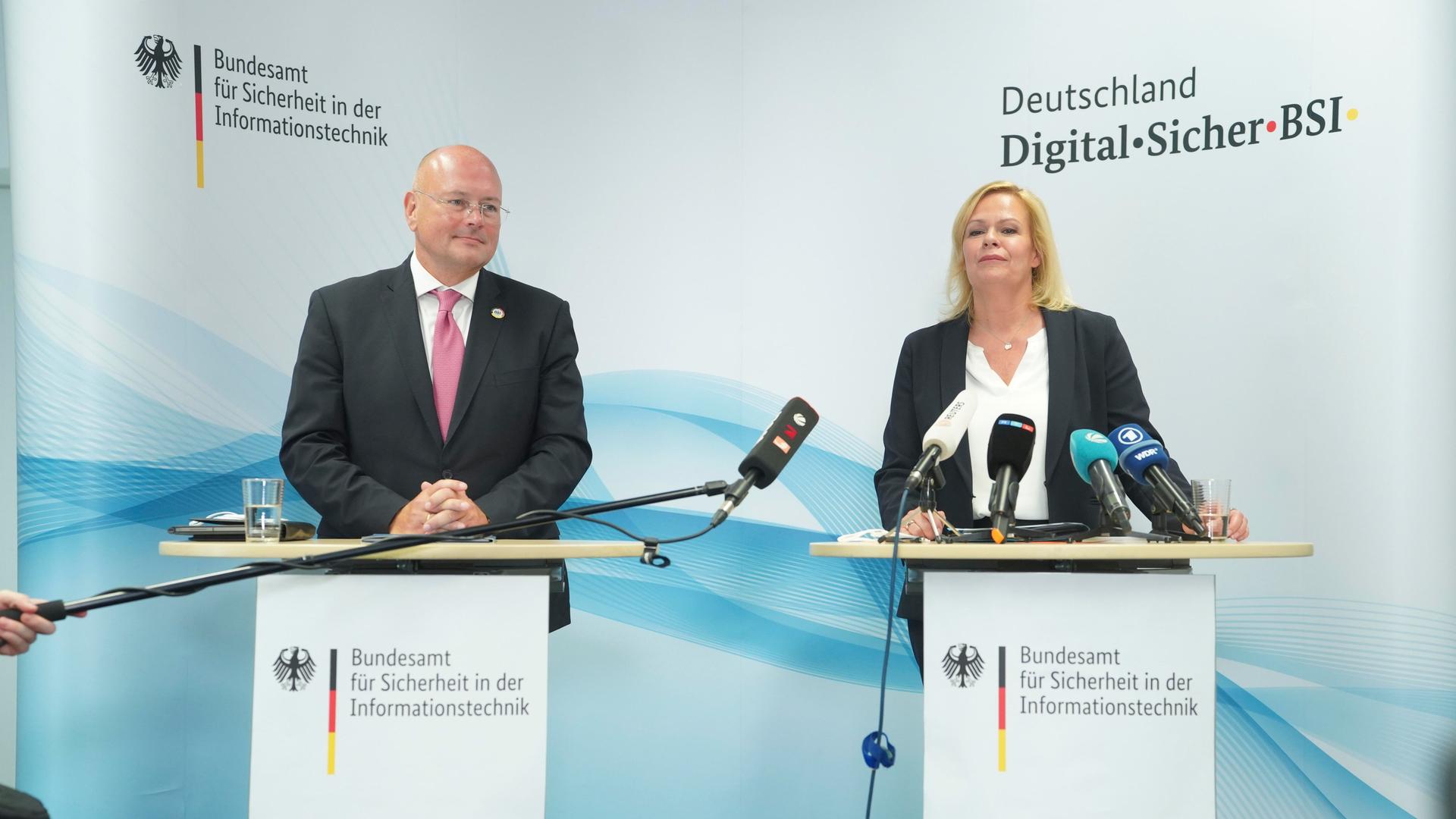 Zwei Personen stehen jeweils an einem Podium mit Mikrofon. Zwei Personen stehen jeweils an einem Podium mit Mikrofon.