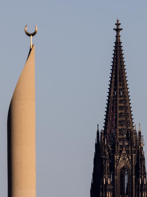 Im Licht in der untergehenden Sonne sind ein Minarett der Zentralmoschee die beiden Türme des Kölner Doms zu sehen. 
