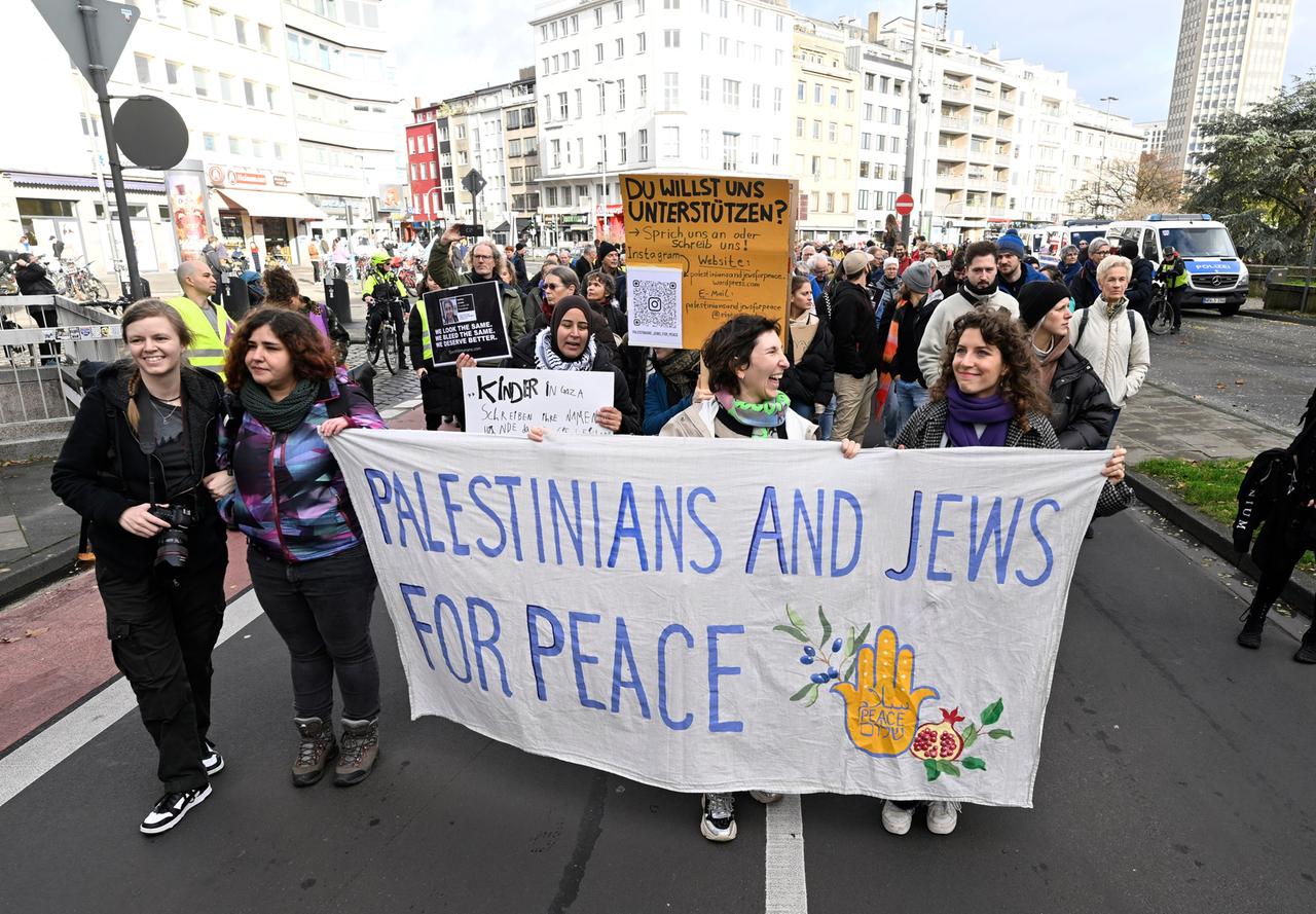 Teilnehmer einer jüdisch-palästinensischen Friedensdemonstration in Köln halten ein Transparent mit der Aufschrift "Palestinians and Jews for Peace". Rund 2.000 Menschen sind laut Polizei zusammengekommen. 