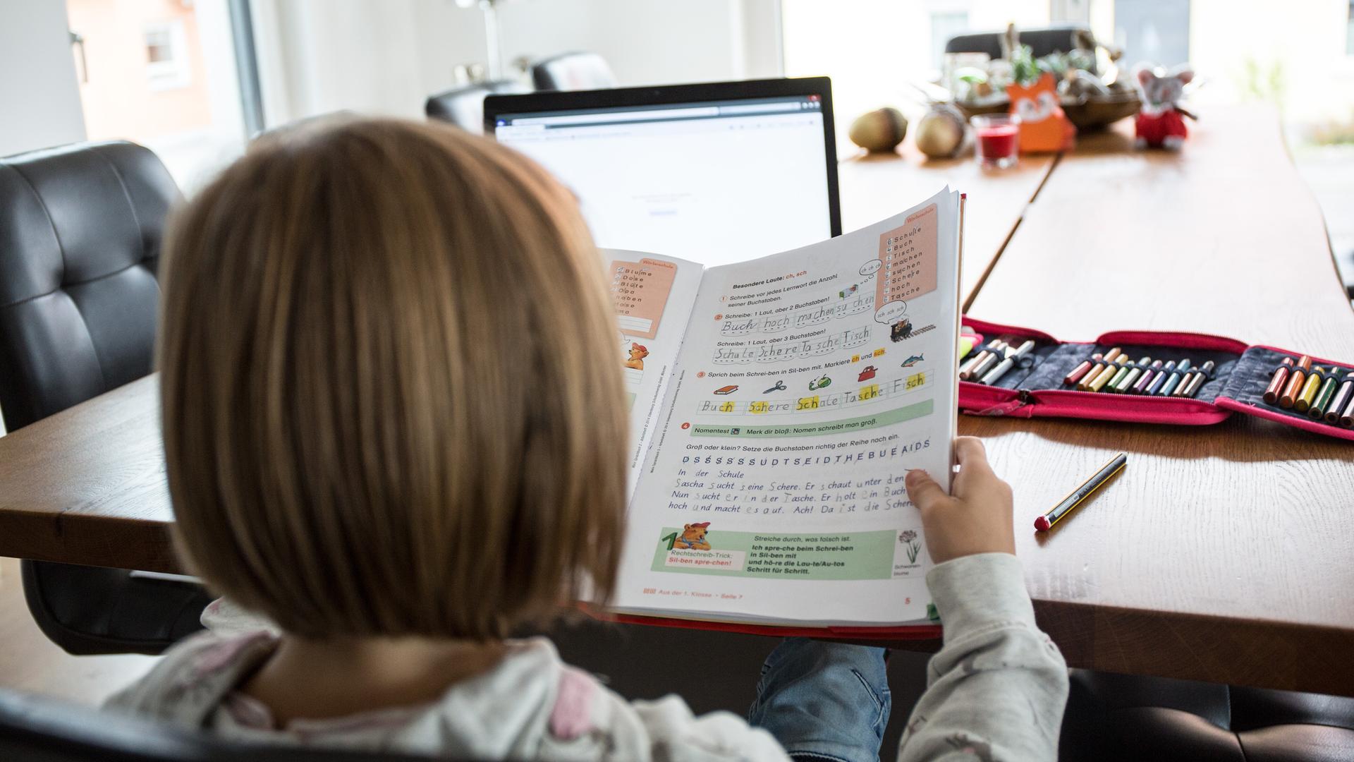 Ein junges Mädchen sitzt am Wohnzimmertisch an einem Laptop und macht Homeschooling zu Hause. Ein junges Mädchen sitzt am Wohnzimmertisch an einem Laptop und macht Homeschooling zu Hause.