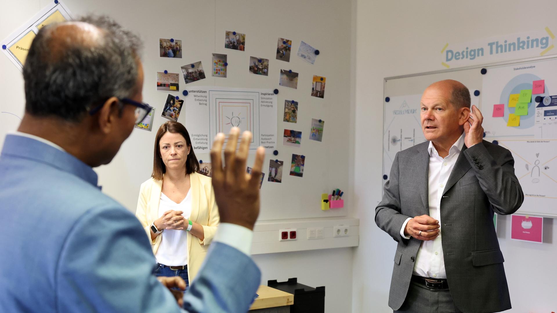 Bundeskanzler Olaf Scholz unterhält sich beim Besuch des Bundesamts für Migration in Nürnberg mit Isabell Cuquejo Nunez, Referat für Behördenentwicklung und Projektmanagement, und Kausik Munsi, Abteilungsleiter digitale Technologien. Bundeskanzler Olaf Scholz unterhält sich beim Besuch des Bundesamts für Migration in Nürnberg mit Isabell Cuquejo Nunez, Referat für Behördenentwicklung und Projektmanagement, und Kausik Munsi, Abteilungsleiter digitale Technologien.