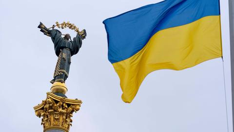 Eine blau-gelbe ukrainische Flagge weht vor dem Unabhängigkeitsdenkmal in Kiew.