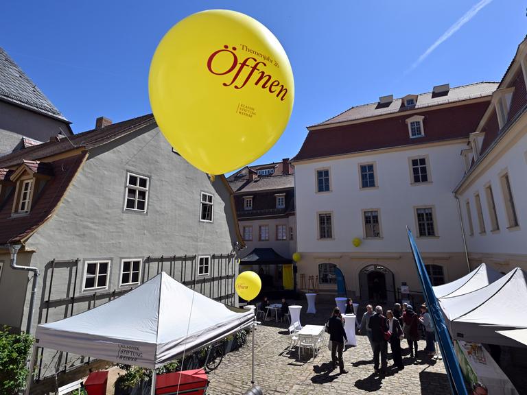 Das Wittumspalais am Tag der Wiedereröffnung. Man sieht einen Ballon mit dem Wort "Öffnen" in der Luft schweben.