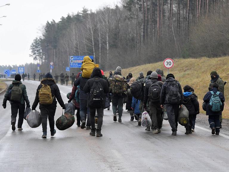 Eine Gruppe von Flüchtlingen auf dem Weg zu einer temporären Unterkunft im Logistikzentrum Bruzgi, am Grenzübergang Bruzgi-Kuznica Bialostocka an der weißrussisch-polnischen Grenze.