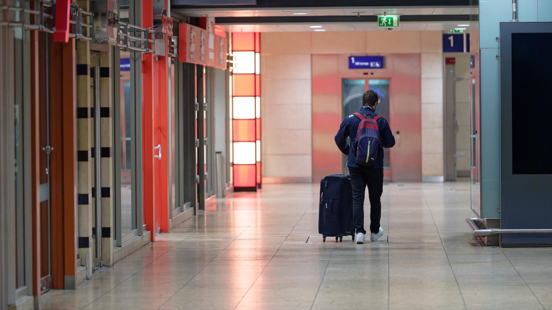 Weitgehend leer ist der Hauptbahnhof Köln, ein einziger Passagier geht mit seinem Gepäck durch einen Gang.