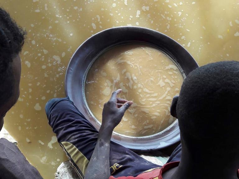 Zwei Kinder arbeiten in mit Chemikalien verunreinigtem Wasser in einer Goldmine im Sudan.