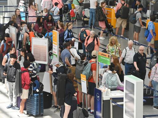 Flugreisende drängeln sich im Terminal 2 am Flughafen Franz Josef Strauss in München.
