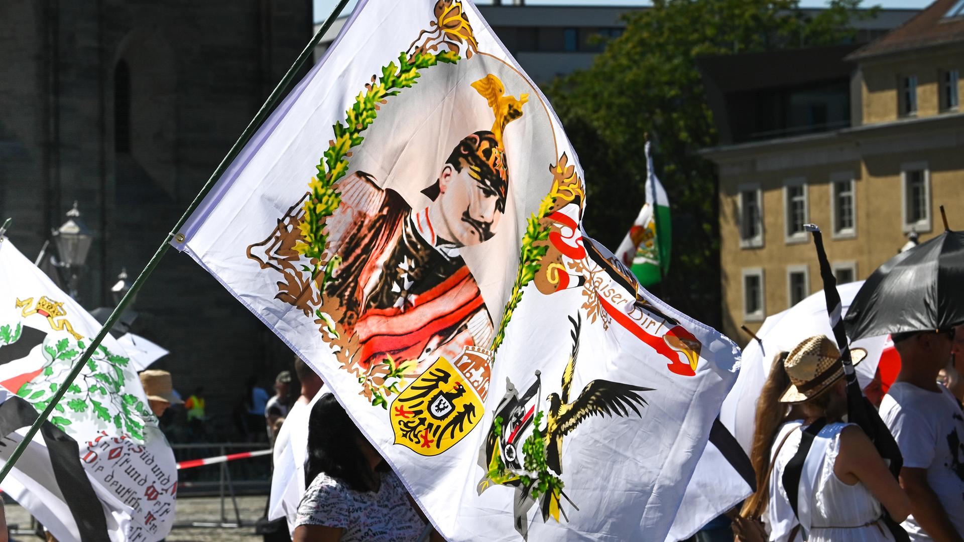 Ein Teilnehmer der Reichsbürgerdemonstration hält eine Fahne mit einem Kaiserabbild. Zur Demonstration der "Reichsbürger"-Szene in Magedburg waren im August 2023 Teilnehmer aus der gesamten Bundesrepublik angereist.