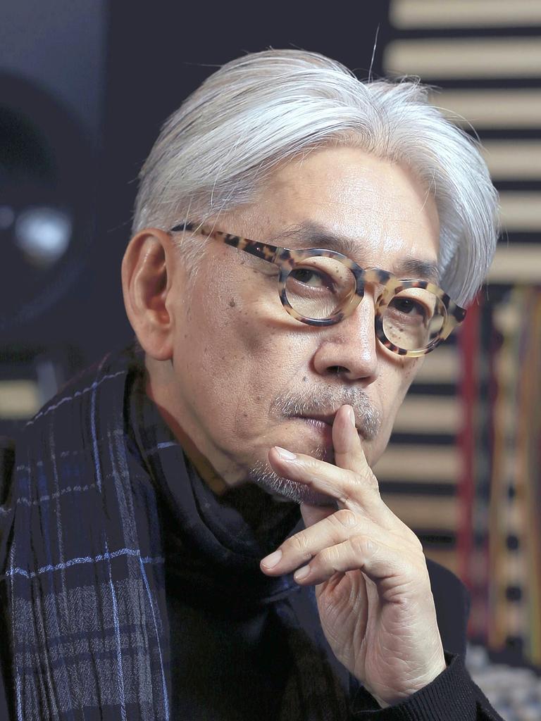 Portraitaufnahme eines älteren weißhaarigen japanischen Mannes, er legt den Finger auf die Lippen