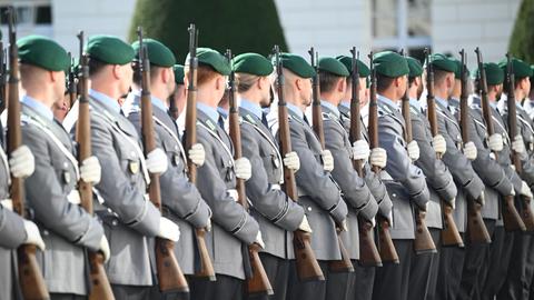 Soldatinnen und Soldaten der Bundeswehr stehen mit Gewehren auf einem offiziellen Empfang.