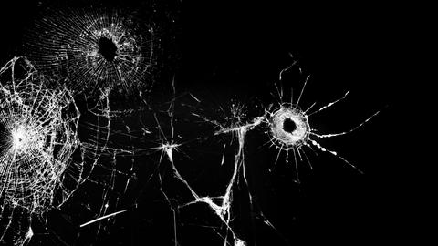Schwarz-weißes Foto einer Glasscheibe mit Schusslöchern