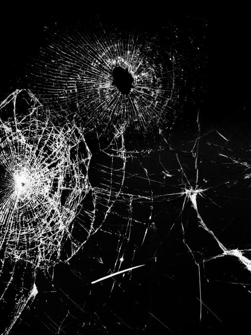 Schwarz-weißes Foto einer Glasscheibe mit Schusslöchern Schwarz-weißes Foto einer Glasscheibe mit Schusslöchern