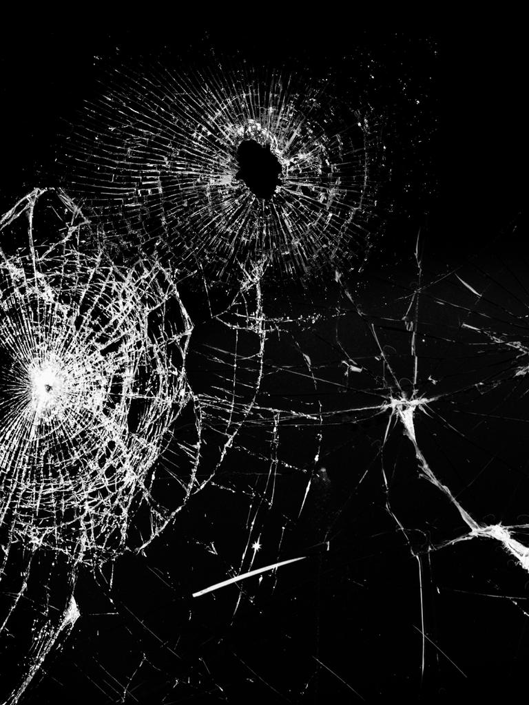 Schwarz-weißes Foto einer Glasscheibe mit Schusslöchern Schwarz-weißes Foto einer Glasscheibe mit Schusslöchern