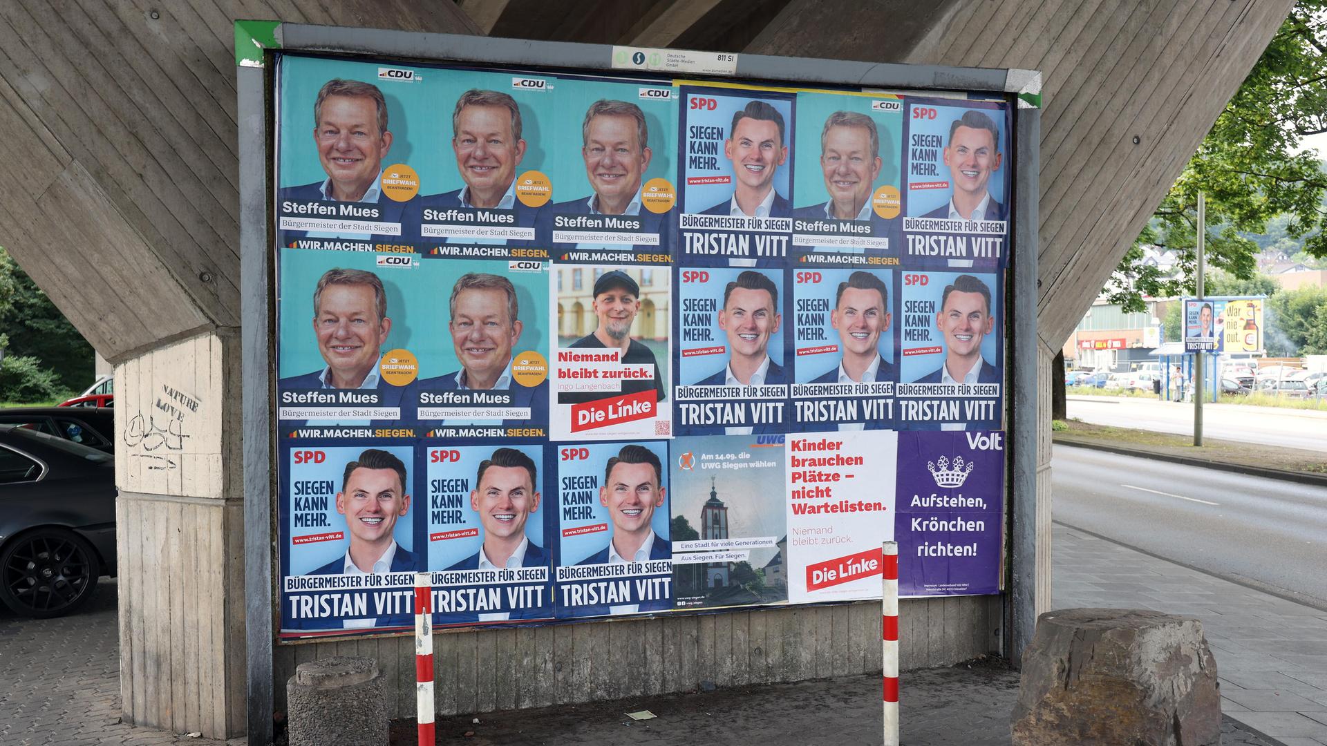 Wahlplakate zeigen die Köpfe mehrerer Kandidaten für das Bürgermeisteramt der Stadt Siegen in Nordrhein-Westfalen Wahlplakate zeigen die Köpfe mehrerer Kandidaten für das Bürgermeisteramt der Stadt Siegen in Nordrhein-Westfalen