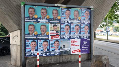 Wahlplakate zeigen die Köpfe mehrerer Kandidaten für das Bürgermeisteramt der Stadt Siegen in Nordrhein-Westfalen